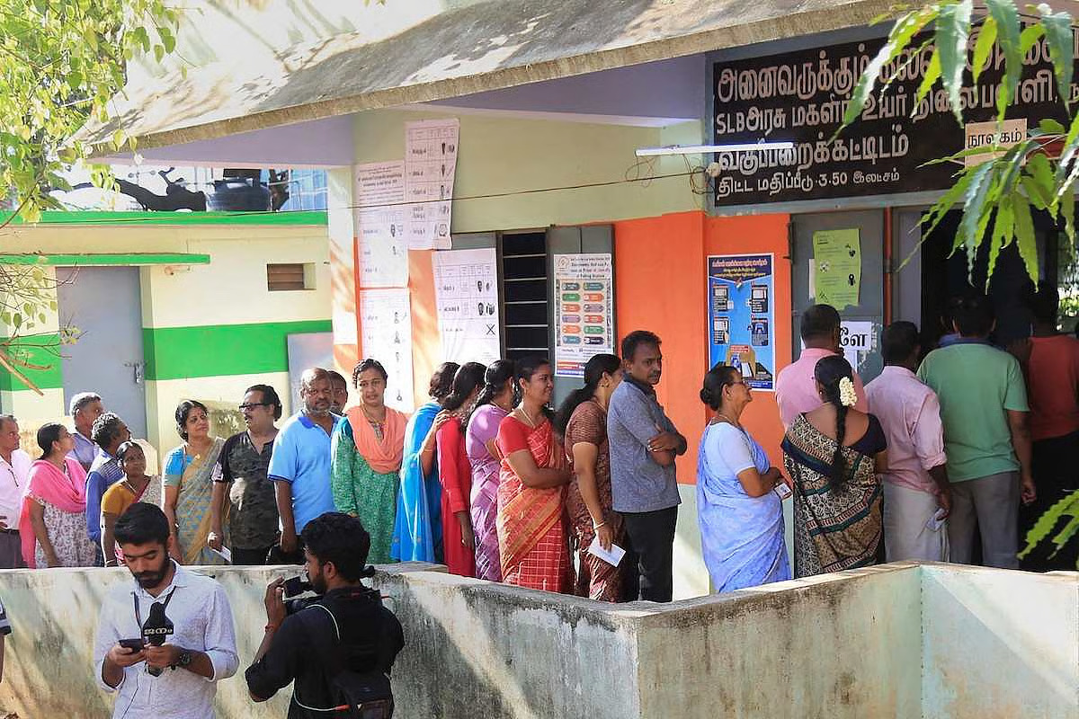 Voters queuing outside a polling station on election day in Tamil Nadu, with election workers visible at the entrance